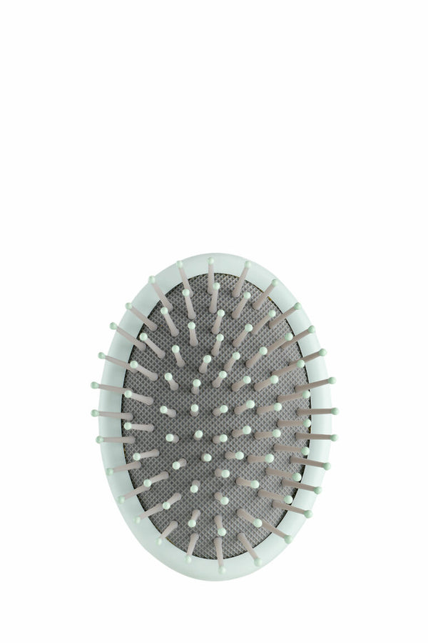 A pastel green oval Kevin Murphy Scalp Spa Brush with ball-tipped bristles and a biodegradable handle for gentle scalp exfoliation